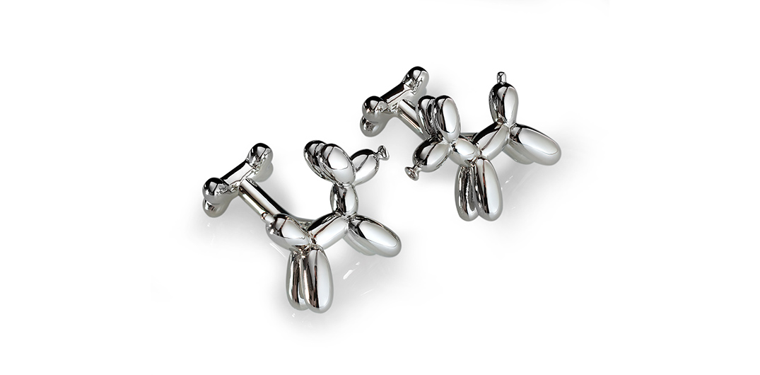 A pair of silver coloured cufflinks in the shape of balloon dogs